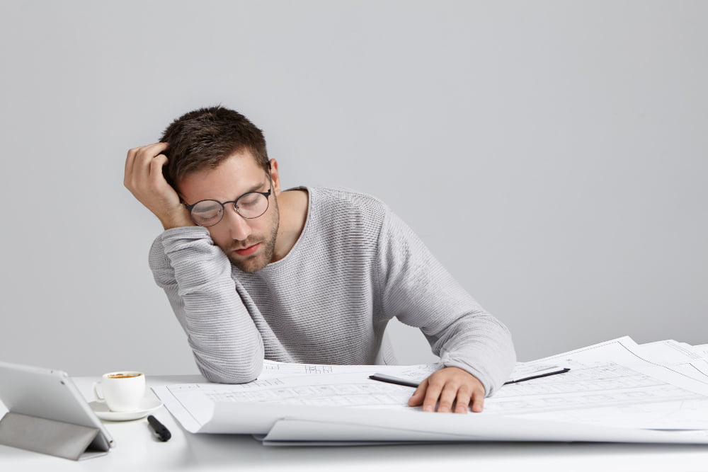 tired young attractive man sleeps work place has much work being fatigue