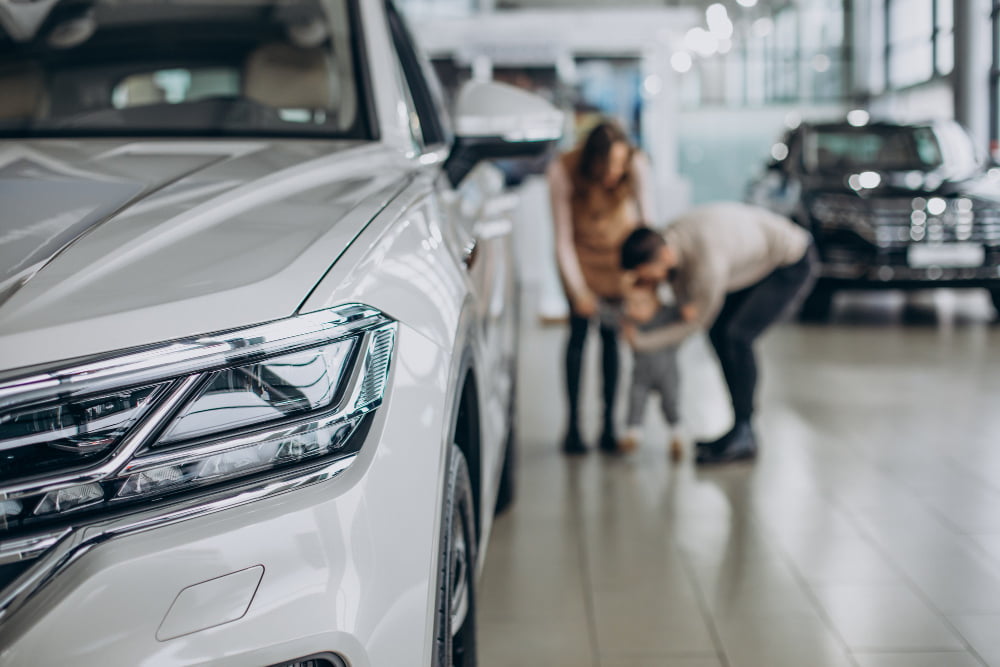 family with baby girl choosing car car salon